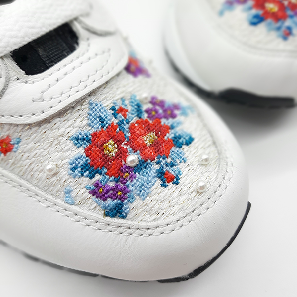 Broderie florale sur paire de sneakers Nike blanches